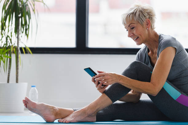 istock Senior woman using smartphone at home after exercise. 1168472708