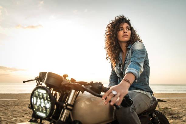 motociclista femenina conduciendo una moto de carreras de café - motociclista fotografías e imágenes de stock