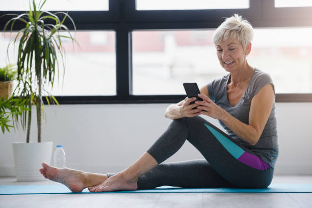istock Senior woman using smartphone at home after exercise. 1168472753
