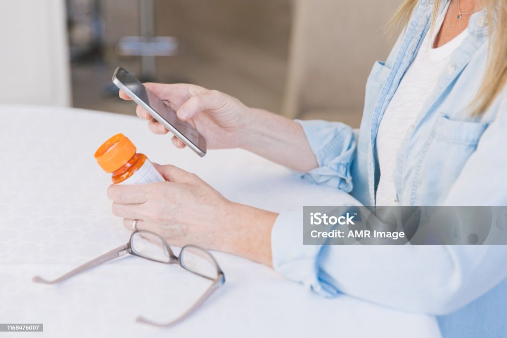 Using a digital tablet Ordering prescription refills using cell phone. Chronic Illness Stock Photo