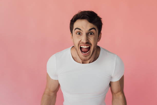 istock front view of angry man screaming and looking at camera isolated on pink 1168477704