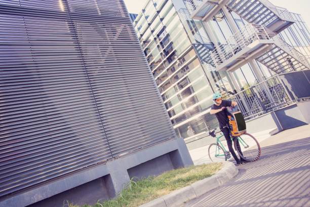 istock Bike messenger with orange backpack in the city 1168478510