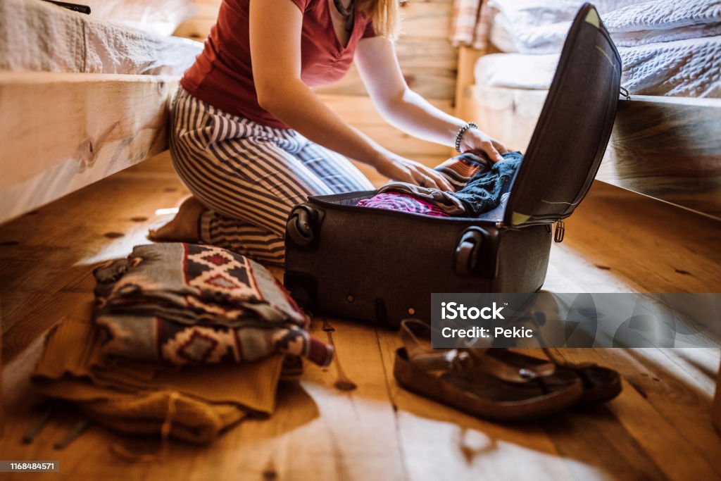 Onherkenbaar vrouw verpakken van bagage in blokhut - Royalty-free Inpakken Stockfoto