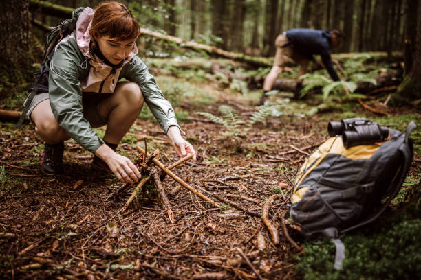 istock Couple making campfire in woodland 1168484585