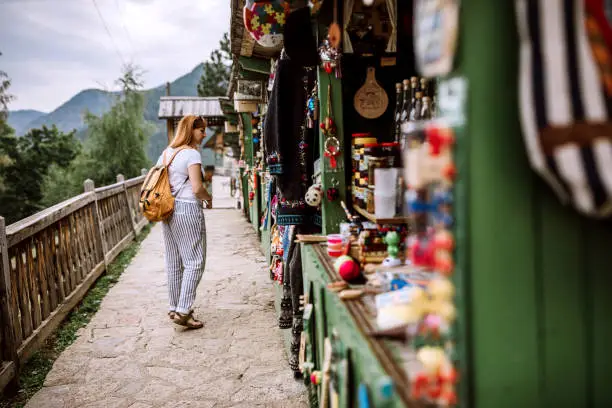 Young Female tourist looking for souvenirs on street market on her summer vacation