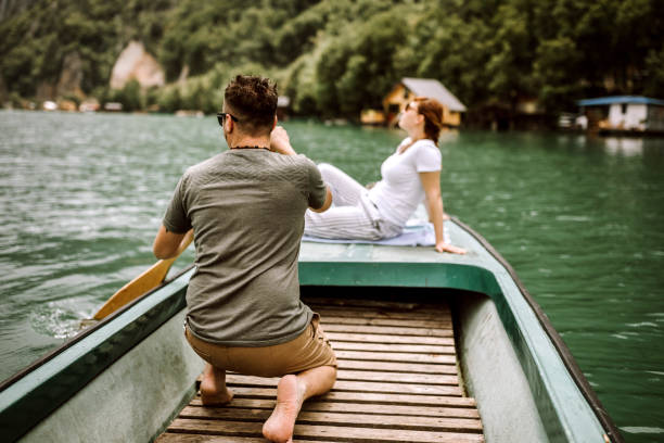 coppia su piccola barca sul lago - canoeing people traveling camping couple foto e immagini stock