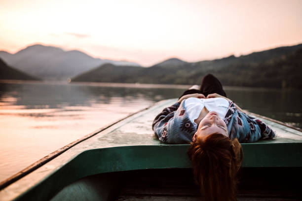 I can hear silence now Woman lying on back on boat on the river with closed eyes relaxation lying on back women enjoyment stock pictures, royalty-free photos & images