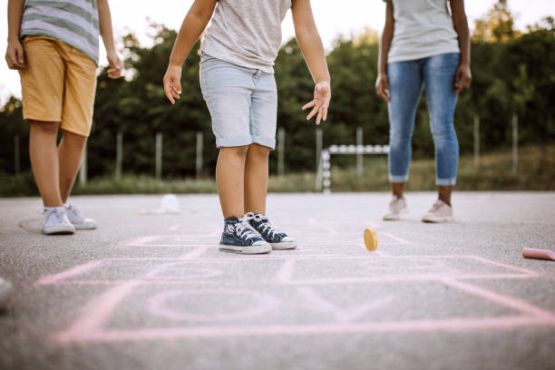 istock Cheerful children playing hopscotch on school yard 1168485365