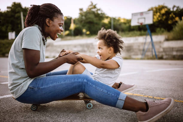 istock Mother and daughter having fun on skateboard 1168485421