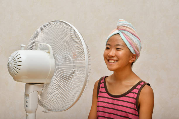 istock Japanese girl cools down after a bath by electric fan 1168486132