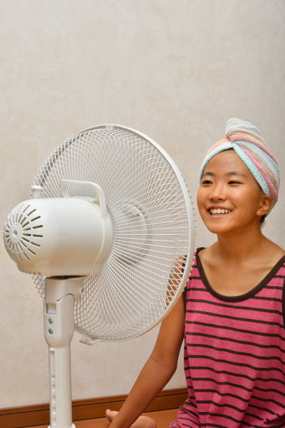 istock Japanese girl cools down after a bath by electric fan 1168486133