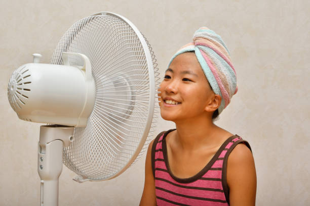 istock Japanese girl cools down after a bath by electric fan 1168486138