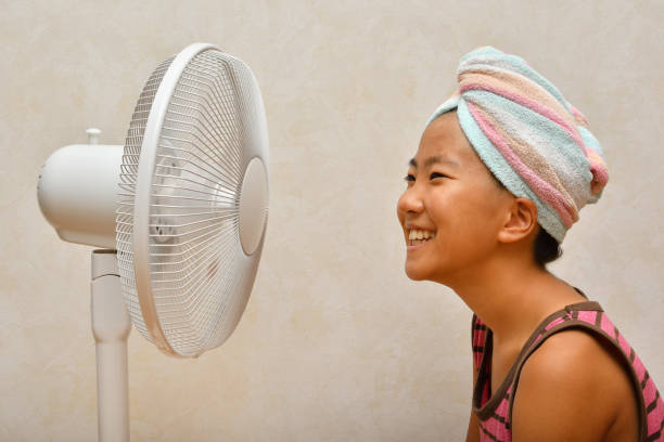 istock Japanese girl cools down after a bath by electric fan 1168486165