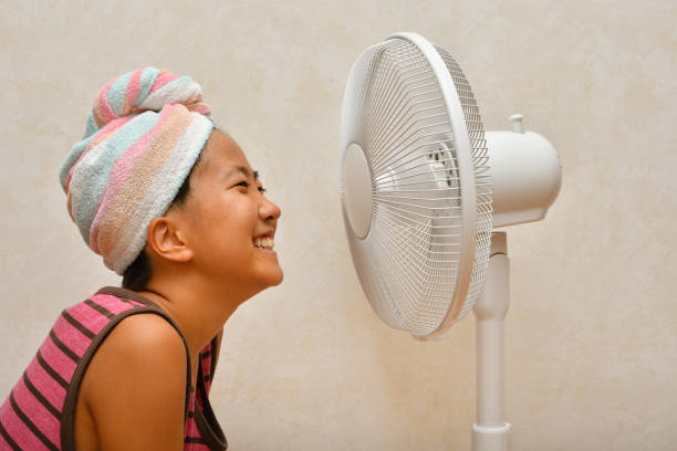 istock Japanese girl cools down after a bath by electric fan 1168486172
