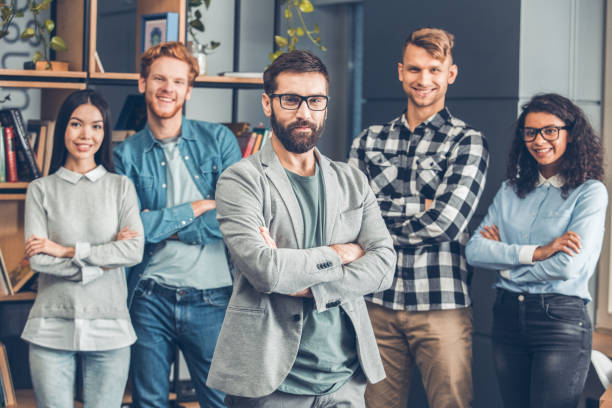 istock Startupers working together at office standing boss close-up looking camera confident while employees smiling 1168488461