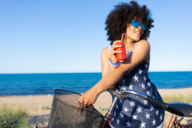 istock Woman with american flag drinking red cocktail 1168489502