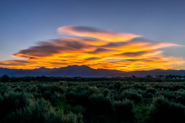 view of sunrise and grass green desert sage brush plants in ranchos de taos valley and green landscape in summer with sunlight clouds - ranchos de taos imagens e fotografias de stock