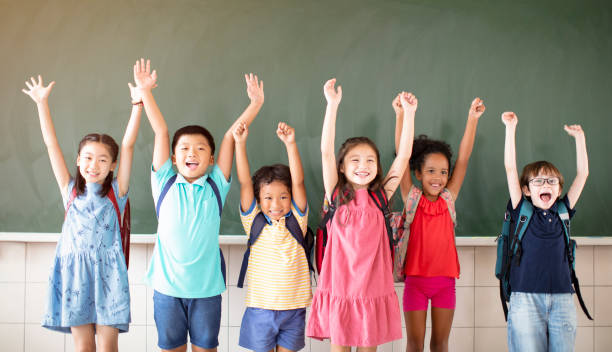 istock Group of diverse young students standing together in classroom 1168505076