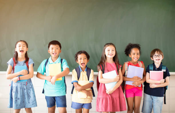 istock Group of diverse young students standing together in classroom 1168505097