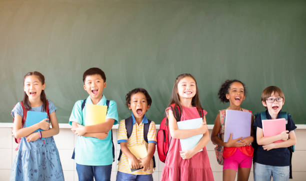 istock Group of diverse young students standing together in classroom 1168505100