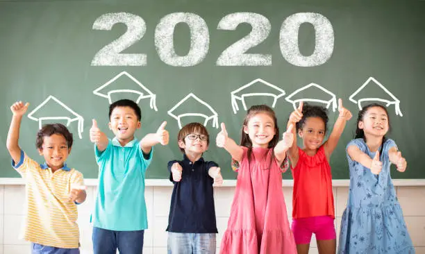 Photo of Multi-ethnic group of school children standing in classroom