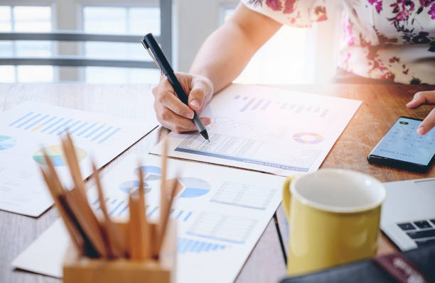 istock Cropped shot of businesswoman using calculator application on mobile phone working with chart and paperwork at her office desk. 1168509754