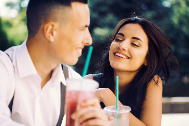 istock Young couple laughing and drinking cold drinks 1168513670