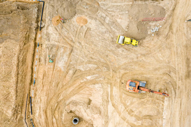 istock top view of construction site. excavators and dump trucks loading sand before road construction 1168514984
