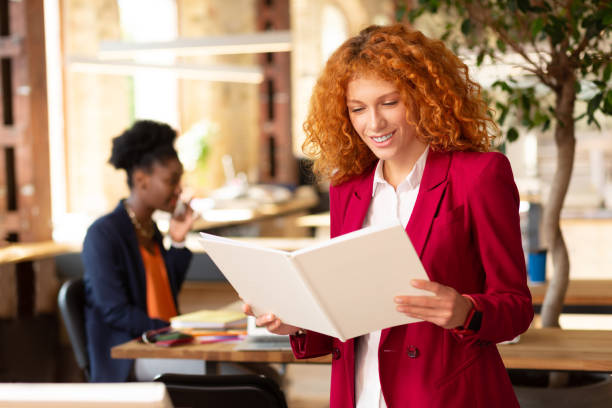 istock Woman holding white notebook standing in the office 1168517495