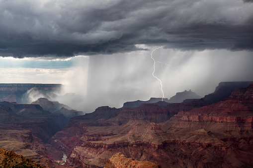 Lightning strikes and heavy rain falls as a monsoon thunderstorm moves through the Grand Canyon, Arizona, USA.