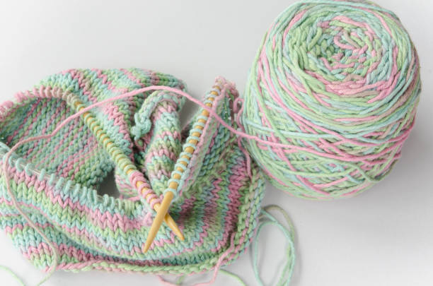 istock Green and pink knitting wool and knitting needles on white background. 1168520449