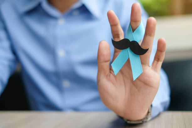 prostate cancer awareness, man hand holding light blue ribbon with mustache for supporting people living and illness. men healthcare and world cancer day concept - medical equipment stethoscope blue healthcare and medicine imagens e fotografias de stock
