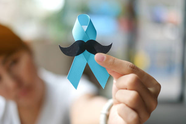 istock Prostate Cancer Awareness, wonan hand holding light Blue Ribbon with mustache for supporting people living and illness. Men Healthcare and World cancer day concept 1168524142