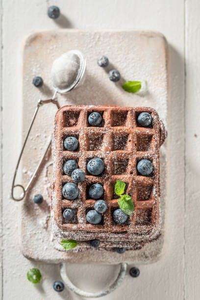 istock Waffles with dark chocolate and fresh blueberries on white table 1168529913