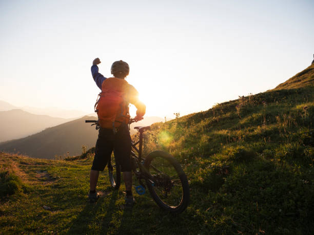 istock Success mountain biker with arm raised at sunset. 1168532119