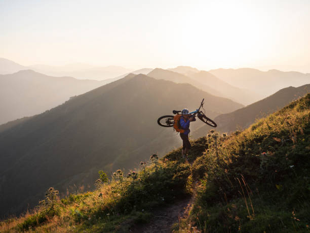 istock A mountain biker carrying his bicycle in the mountains at sunset. 1168532121