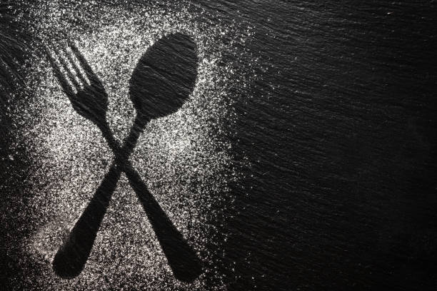 istock Spoon and fork silhouette made with flour on dark texture background, up horizontal view 1168534812