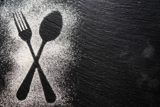 istock Spoon and fork silhouette made with flour on dark texture background, up horizontal view 1168534831