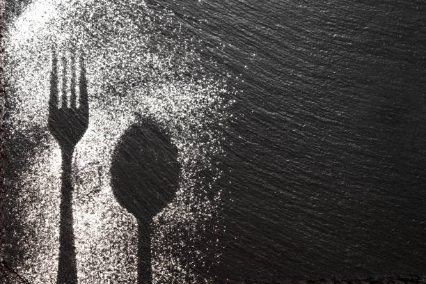 istock Spoon and fork silhouette made with flour on dark texture background, up horizontal view 1168534861