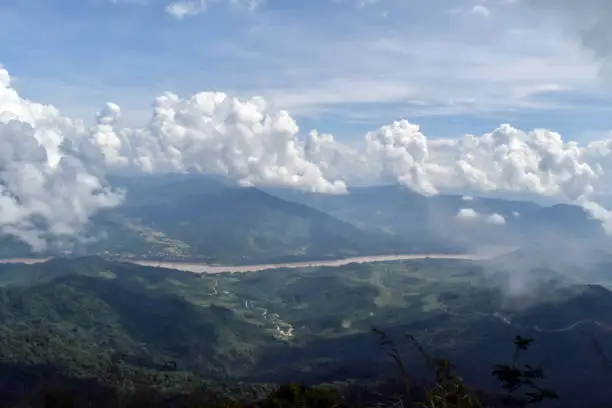 Photo of Mist-shrouded mountain peaks. Bright blinding sun. Blue sky. Fog. Mountains landscape. Highlands nature.