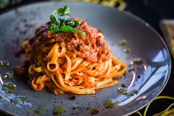 delicious italian spaghetti bolognese with minced beef sauce, tomatoes, carrots & fresh basil