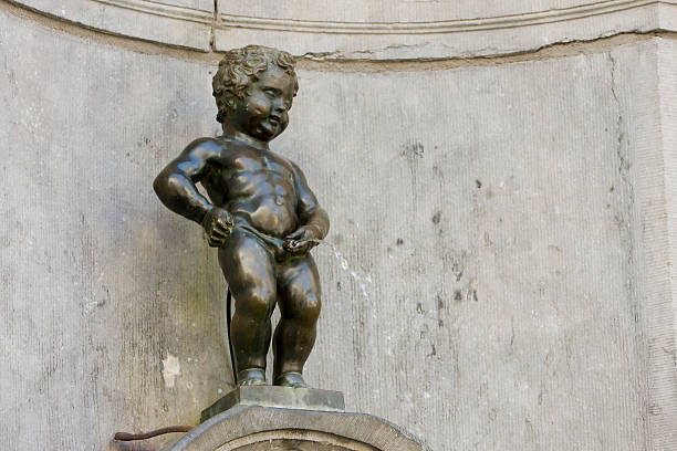A statue on a building of a little man peeing The Manneken Pis manneken pis statue in brussels belgium stock pictures, royalty-free photos & images