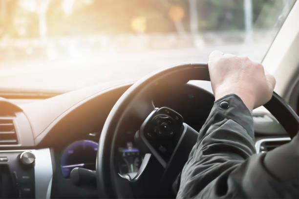 istock Driver hand hold steering wheel to control and turn right on sharp curve road. 1168548513