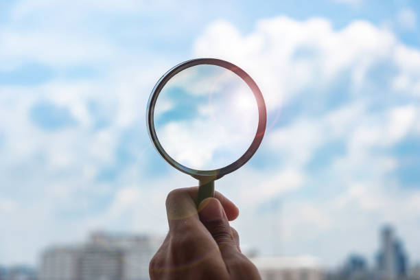 istock hands holding glass magnify against blue sky background. Business Explore, Searching, Discovery and Vision concepts 1168548861