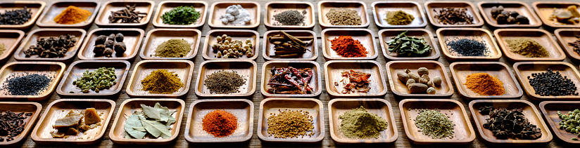 Many colorful, organic, dried, vibrant Indian food, ingredient spices displayed in wooden trays on an old wooden background. Shot from a high angle, nice color contrast. Shallow depth of field.
