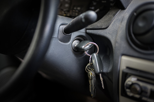 ignition key in the lock of an older car, selected focus, narrow depth of field