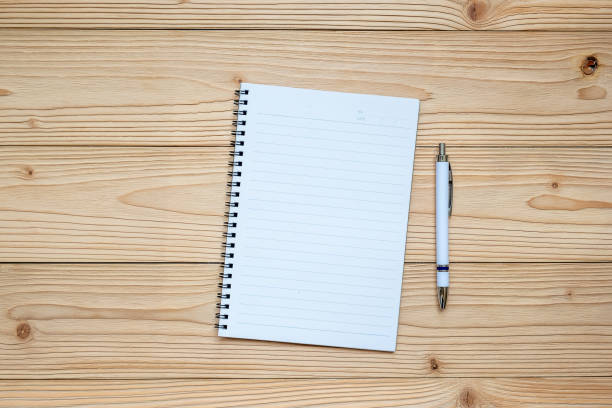 istock blank notebook with pen on wooden background. top view and copy space for your text 1168549696