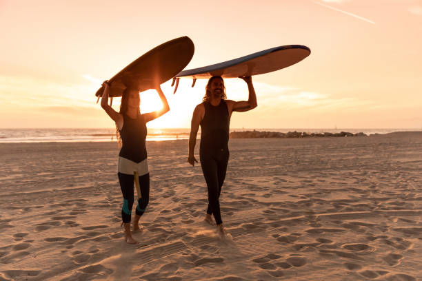 istock Cool couple in Venice going to surf in the Pacific Ocean 1168549766