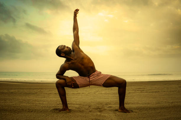 istock dramatic contemporary dance choreographer doing ballet beach workout . young attractive and athletic afro black American man dancing on sunrise doing performance rehearsal 1168550044