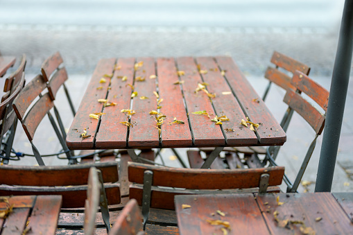 Furniture for a café or restaurant terrace that is stored on a sidewalk \nPhoto that illustrates the confinement and closure of restaurant and specialized businesses.\n(Cafes, bistros, restaurants)